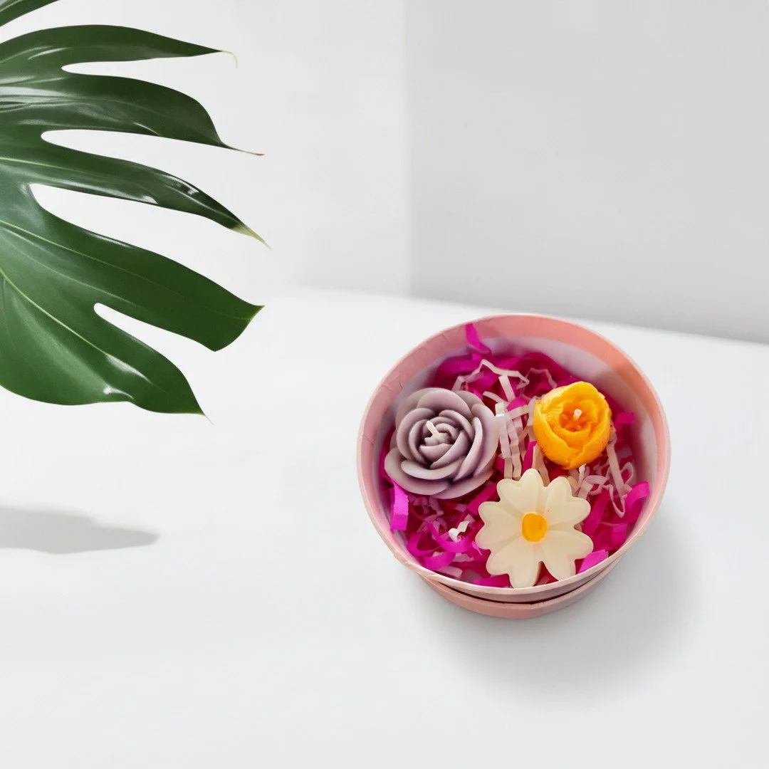 Set floral en caja circular rosa con velas lavanda naranja y margarita